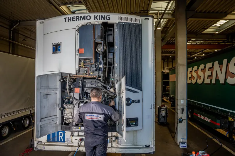 Technikas aptarnauja Thermo King šaldymo agregatą ant puspriekabės